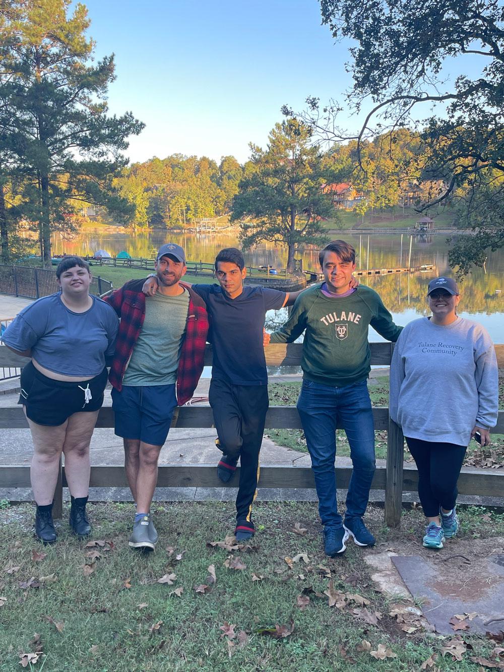 Group photo of TRC members leaning against gate at Camp Cosby
