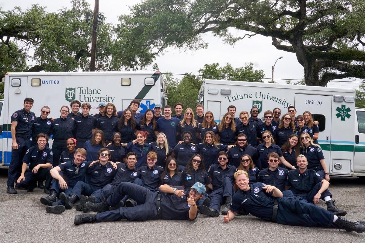 Members of Tulane EMS posing in front of their two ambulances.