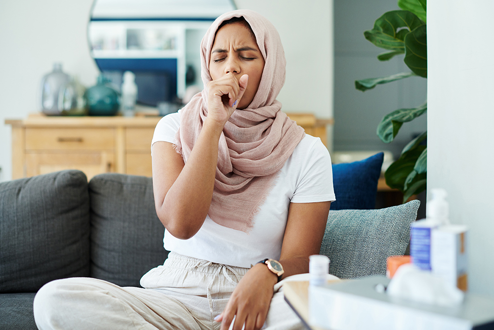 woman in hijab coughing