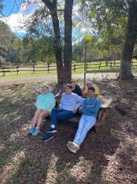 Students relaxing under trees at Camp Cosby