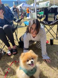Student petting dog outside during Homecoming tailgate